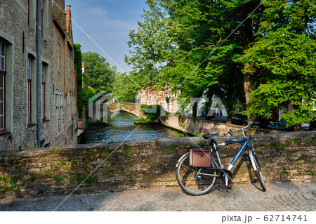 Bicycle on a bridge near canal and old houses in Bruges. Brugge, Belgium 62714741