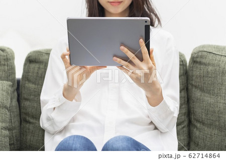 リビングでタブレットを操作する女性 62714864