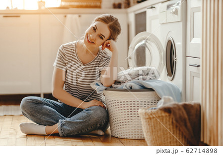 Happy housewife woman in laundry room with washing Happy housewife woman in laundry room with washing 62714898