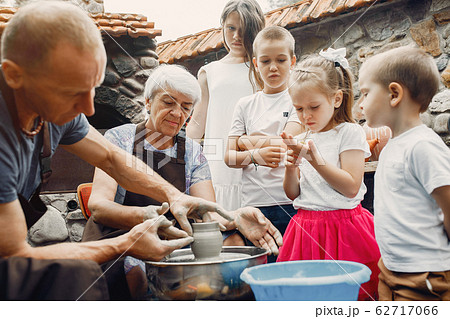 Grandparents with a grandchildren make jug in pottery 62717066