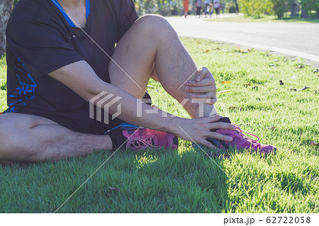 Ankle sprained. man suffering from ankle injury while running at park. Healthcare and sport concept. Ankle sprained. man suffering from ankle injury while running at park. Healthcare and sport concept. 62722058