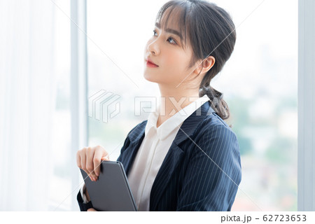 A business woman using tablet beside the window 62723653
