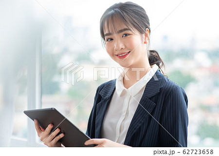 A business woman using tablet beside the window 62723658