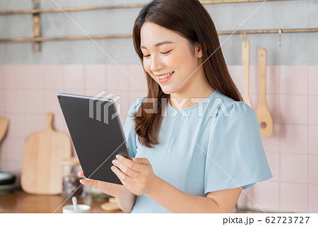 A beauty woman using a tablet in the kitchen 62723727