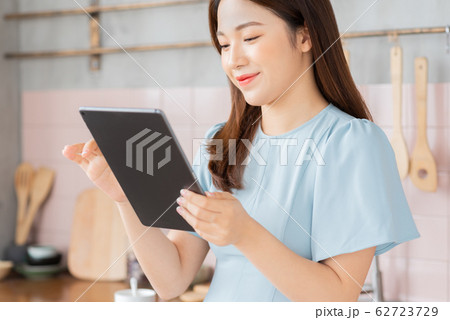 A beauty woman using tablet in the kitchen 62723729