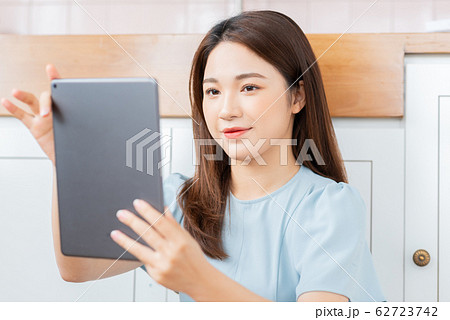 A beauty woman using tablet in the kitchen A beauty woman using tablet in the kitchen 62723742