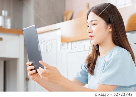 A beauty woman using tablet in the kitchen A beauty woman using tablet in the kitchen 62723748