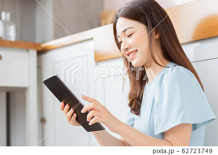 A beauty woman using tablet in the kitchen A beauty woman using tablet in the kitchen 62723749