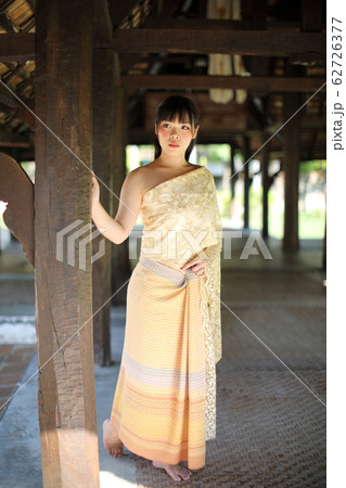 Portrait of Thai female with traditional Thai dress with temple background Portrait of Thai female with traditional Thai dress with temple background 62726377