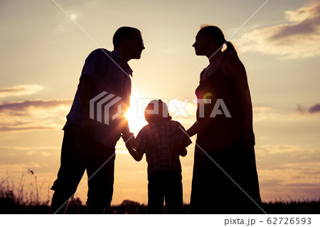 Happy family standing in the park at the sunset 62726593
