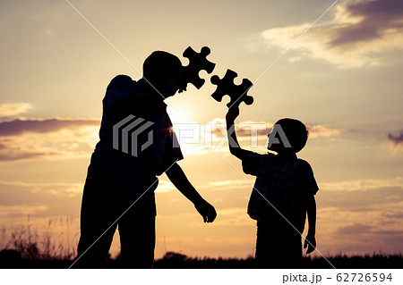 Father and son walking on the field at the sunset Father and son walking on the field at the sunset 62726594
