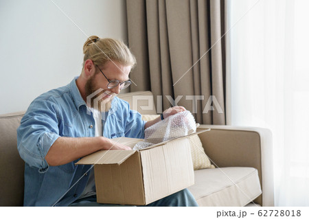 Happy male customer open cardboard box receive postal mail delivery package 62728018