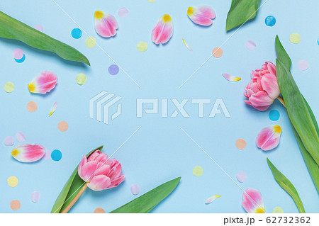 Pink tulips and colorful confetti on a blue background. 62732362