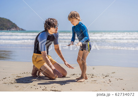 Father or instructor teaching his son how to surf in the sea on vacation or holiday. Travel and Father or instructor teaching his son how to surf in the sea on vacation or holiday. Travel and 62734072