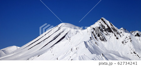 Snowy mountains peak and blue clear sky at sunny 62734241