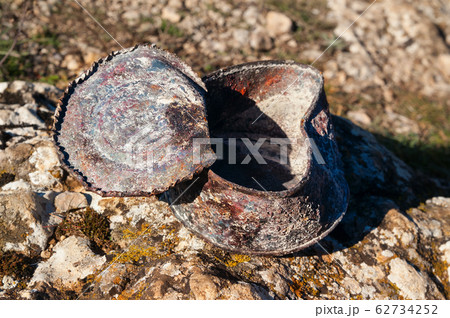 Old rusty tin can covered with ash on stone at Old rusty tin can covered with ash on stone at 62734252