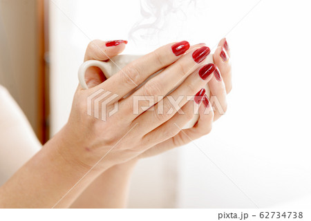 close-up of the hands of a young woman with a cup 62734738