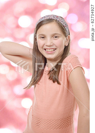 Adorable preteen girl, pink bokeh background 62734927