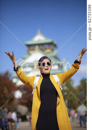 asian woman atanding infront of osaka castle with asian woman atanding infront of osaka castle with 62735396