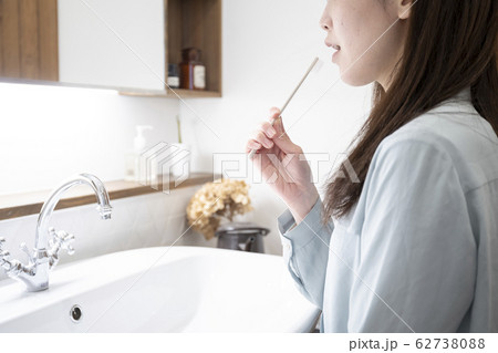 洗面化粧台で歯磨きをする若い女性 洗面化粧台で歯磨きをする若い女性 62738088