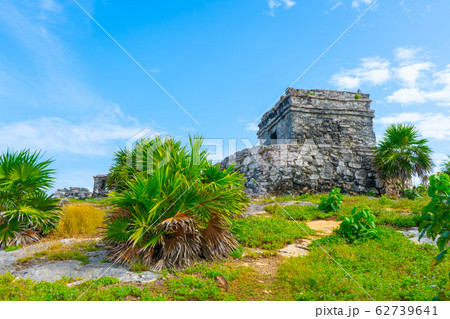 Ruins of ancient Tulum. Architecture of ancient maya. View with temple and other old buildings, houses. Blue sky and lush greenery of nature. travel photo. Wallpaper or background. Yucatan. Ruins of ancient Tulum. Architecture of ancient maya. View with temple and other old buildings, houses. Blue sky and lush greenery of nature. travel photo. Wallpaper or background. Yucatan. 62739641