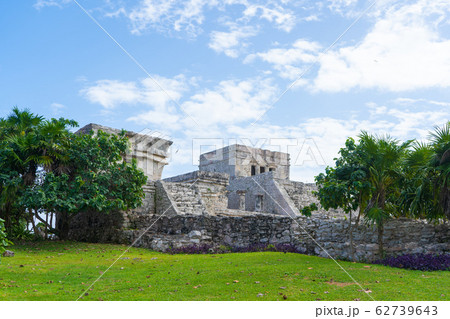 Ruins of ancient Tulum. Architecture of ancient maya. View with temple and other old buildings, houses. Blue sky and lush greenery of nature. travel photo. Wallpaper or background. Yucatan. Ruins of ancient Tulum. Architecture of ancient maya. View with temple and other old buildings, houses. Blue sky and lush greenery of nature. travel photo. Wallpaper or background. Yucatan. 62739643