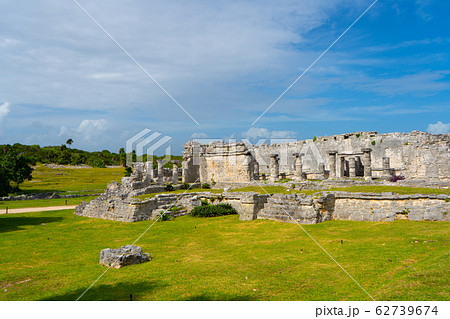 Ruins of ancient Tulum. Architecture of ancient maya. View with temple and other old buildings, houses. Blue sky and lush greenery of nature. travel photo. Wallpaper or background. Yucatan. 62739674