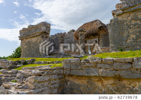 Ruins of ancient Tulum. Architecture of ancient maya. View with temple and other old buildings, houses. Blue sky and lush greenery of nature. travel photo. Wallpaper or background. Yucatan. 62739678