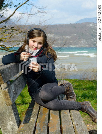 a young teenager listening to music on his phone 62742039