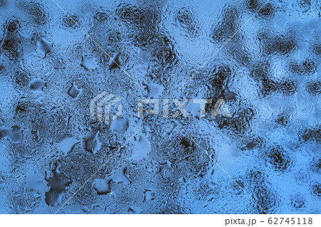 Abstract blue background with raindrops on glass Abstract blue background with raindrops on glass 62745118