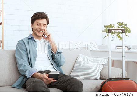 Happy man calling taxi and holding passport Happy man calling taxi and holding passport 62746175