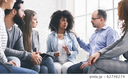 Emotional black woman sharing her story during therapy session in rehab 62746274