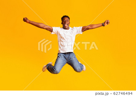 Happy excited african man jumping in air, dancing Happy excited african man jumping in air, dancing 62746494