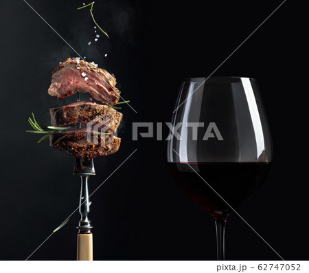 Grilled beef steak with rosemary and glass of red Grilled beef steak with rosemary and glass of red 62747052