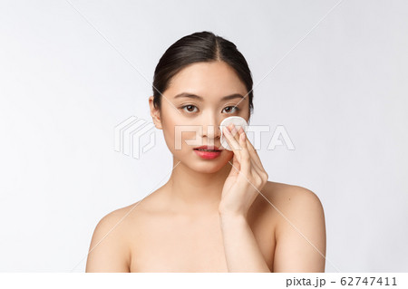 skin care woman removing face makeup with cotton swab pad - skin care concept. Facial closeup of beautiful mixed race model with perfect skin. skin care woman removing face makeup with cotton swab pad - skin care concept. Facial closeup of beautiful mixed race model with perfect skin. 62747411