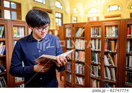 Smart Asian man student reading book in library Smart Asian man student reading book in library 62747774