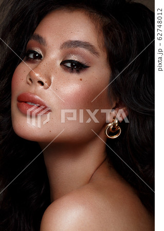 Beautiful Asian brunette model : volume curls, classic makeup and sexy lips. The beauty face. 62748012