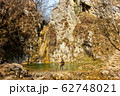 Female hiker arrives and admires a waterfall with a beautiful puddle of water 62748021