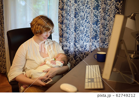 Young mother holding baby, chating by smartphone Young mother holding baby, chating by smartphone 62749212