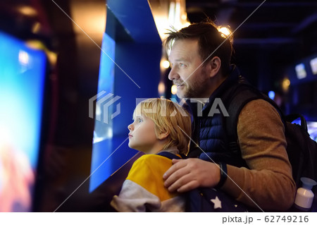 Little boy with father watching fishes in seaquarium Little boy with father watching fishes in seaquarium 62749216