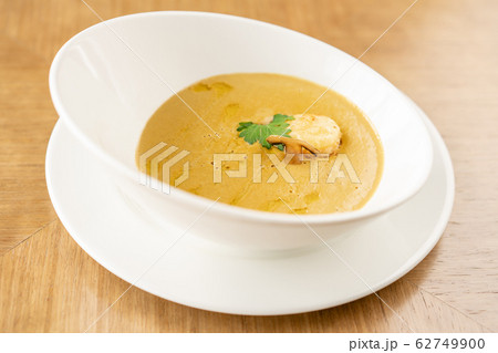 Cream-soup with porcini mushroom with croutons on wooden table. Restaurant menu 62749900