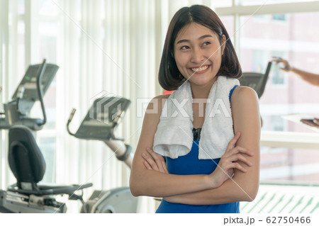 Portrait of a cheerful sports woman standing arms 62750466