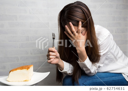 ケーキを我慢する女性. ケーキを我慢する女性. 62754631