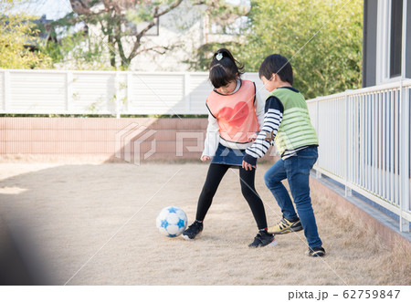 庭でサッカーの練習をする男の子と女の子 庭でサッカーの練習をする男の子と女の子 62759847