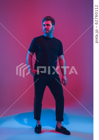 Young caucasian musician singing, dancing in neon light 62760112