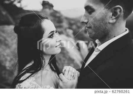 Loving husband and woman on the background of the mountains. Loving couple emotionally spends time Loving husband and woman on the background of the mountains. Loving couple emotionally spends time 62760261