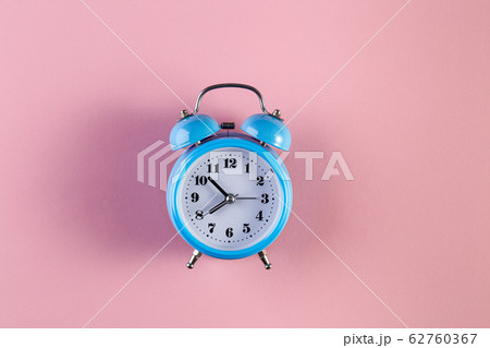 Blue vintage alarm clock on light pink color 62760367