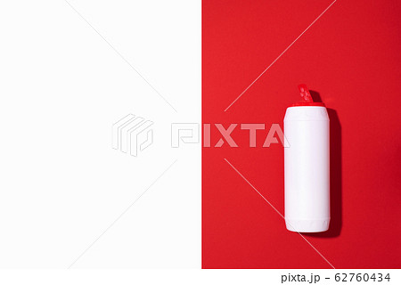 White plastic bottle of detergent powder or cleaning agent on red background. Copy space. Top view. Flat lay. Household chemicals concept 62760434
