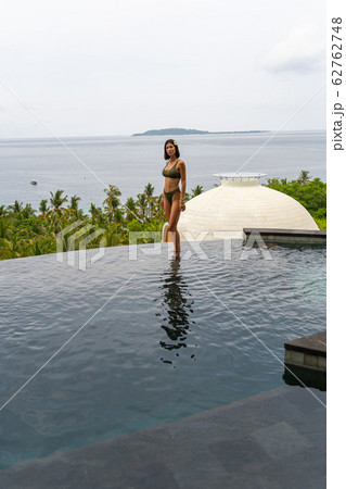 Caucasian woman standing in an outdoor swimming pool 62762748