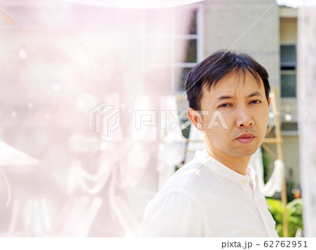 Happy Thai asian smart man wear casual white shirt is thinking, peeking back white soft lace fabric curtain on sunshine in relaxing time summer. Asia Lifestyle chill out at outdoor. Look at camera. Happy Thai asian smart man wear casual white shirt is thinking, peeking back white soft lace fabric curtain on sunshine in relaxing time summer. Asia Lifestyle chill out at outdoor. Look at camera. 62762951
